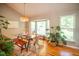 Charming dining area with a glass table, hardwood floors, a large window and lots of plants at 101 Lakeshore Dr. Dr, Durham, NC 27713