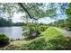 Walking trail alongside a pond, with abundant trees, and a blue bench at 101 Lakeshore Dr. Dr, Durham, NC 27713