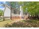 A view of the back exterior of a home showing brick foundation, siding, and shaded yard at 1021 S Fieldhaven Dr, Fuquay Varina, NC 27526