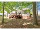 Home's backyard view with mature trees and private wooden deck and backyard at 1021 S Fieldhaven Dr, Fuquay Varina, NC 27526