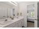 Ensuite bathroom with dual sinks, large mirror and vanity adjacent to bedroom at 1021 S Fieldhaven Dr, Fuquay Varina, NC 27526