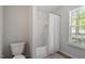 Well-lit bathroom with shower over tub and window with privacy blinds at 1021 S Fieldhaven Dr, Fuquay Varina, NC 27526