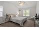 Light-filled bedroom boasts neutral décor, vaulted ceiling with fan, and picture window at 1021 S Fieldhaven Dr, Fuquay Varina, NC 27526