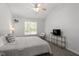 Light-filled bedroom boasts neutral décor, vaulted ceiling with fan, and picture window at 1021 S Fieldhaven Dr, Fuquay Varina, NC 27526