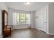 Bright bedroom with hardwood floors and large windows overlooking landscaped backyard at 1021 S Fieldhaven Dr, Fuquay Varina, NC 27526