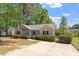 A well-maintained, single-story home with a cozy porch, lawn, and mature trees at 1021 S Fieldhaven Dr, Fuquay Varina, NC 27526