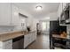 Functional kitchen with white cabinets, black appliances, and a view to the breakfast area at 1021 S Fieldhaven Dr, Fuquay Varina, NC 27526
