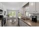 Bright kitchen with stainless appliances, stone countertops, white cabinetry, and adjacent dining area at 1021 S Fieldhaven Dr, Fuquay Varina, NC 27526