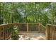 A lovely wooden back deck surrounded by green trees and foliage at 104 Farnham Ct, Garner, NC 27529