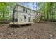 Backyard with a wooden deck, stairs, mature trees, and a partially fenced yard at 104 Farnham Ct, Garner, NC 27529