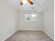 Bright bedroom features a ceiling fan, neutral walls, and a window view of lush greenery at 104 Farnham Ct, Garner, NC 27529