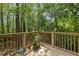 Wooden deck with a lush green view, complete with potted plants and a watering can at 104 Farnham Ct, Garner, NC 27529