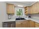 Bright kitchen featuring wood cabinets, stainless steel appliances, and a black sink under a window at 104 Farnham Ct, Garner, NC 27529