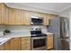 Well-lit kitchen features stainless steel appliances, wood cabinets, and light countertops at 104 Farnham Ct, Garner, NC 27529
