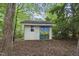 Shed with painted flower decor and a secure door, nestled in a tranquil backyard setting at 104 Farnham Ct, Garner, NC 27529