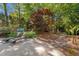Serene backyard with stone patio, lounge chairs, lush landscaping, and a swing set at 108 Martinique Pl, Cary, NC 27511