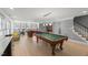 Open basement recreation area with a pool table, fireplace, and abundant natural light from the many windows at 108 Martinique Pl, Cary, NC 27511