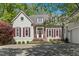 Charming home exterior featuring a circular driveway, stone accents, red shutters and a welcoming front entrance at 108 Martinique Pl, Cary, NC 27511