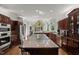 Beautiful, large kitchen with island, granite countertops, dark wood cabinetry, and modern appliances at 108 Martinique Pl, Cary, NC 27511