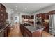 Elegant kitchen featuring a large island, dark wood cabinetry, and stainless steel appliances at 108 Martinique Pl, Cary, NC 27511