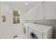Bright laundry room with white cabinetry, modern washer and dryer, and a window with natural light at 108 Martinique Pl, Cary, NC 27511