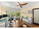 Inviting home office with hardwood floors, bright windows, and a stylish glass desk and ceiling fan at 108 Martinique Pl, Cary, NC 27511