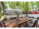 Backyard featuring a greenhouse, outdoor dining area, and tiered brick landscaping perfect for entertaining at 1107 Daleland Dr, Raleigh, NC 27612