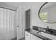 Bathroom featuring a black granite vanity, white cabinets, and modern fixtures at 1107 Daleland Dr, Raleigh, NC 27612