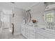 Well-lit bathroom with double sink vanity, white cabinetry and tiled floors at 1107 Daleland Dr, Raleigh, NC 27612