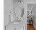 Elegant bathroom with marble countertop, white cabinets, and an oval mirror at 1107 Daleland Dr, Raleigh, NC 27612