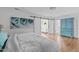 Bright bedroom with hardwood floors, blue accents, and a sliding barn door leading to another room at 1107 Daleland Dr, Raleigh, NC 27612