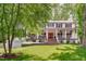 Charming home with a red door, white pillars, and a wide front porch, set on a lush lawn at 1107 Daleland Dr, Raleigh, NC 27612