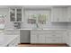 Bright kitchen features white cabinets, stainless steel appliances, and large window overlooking the backyard at 1107 Daleland Dr, Raleigh, NC 27612