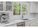 Bright kitchen featuring a stainless steel espresso maker, sink, and view of a lush, green backyard at 1107 Daleland Dr, Raleigh, NC 27612