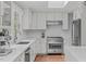This kitchen includes white cabinets, stainless steel appliances, and herringbone backsplash at 1107 Daleland Dr, Raleigh, NC 27612