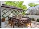 Outdoor patio dining area featuring seating for eight, brick features, and a view of the greenhouse at 1107 Daleland Dr, Raleigh, NC 27612