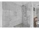 Beautiful shower with marble-look tile, glass enclosure, and modern fixtures at 1107 Daleland Dr, Raleigh, NC 27612