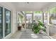 Bright sunroom with screened windows, painted brick, and potted plants, creating a cozy and inviting atmosphere at 1107 Daleland Dr, Raleigh, NC 27612