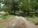 Gravel driveway leading through mature trees to the main residence, providing a secluded entrance at 113 Pineview Dr, Louisburg, NC 27549