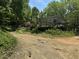 Home with a cozy deck, set back from the road, nestled among lush trees and greenery at 113 Pineview Dr, Louisburg, NC 27549