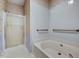 Neutral bathroom featuring a shower with glass door and a soaking tub at 123 Alan Ln, Clayton, NC 27520