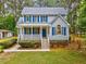 Charming two-story home features a covered front porch, blue shutters, and mature landscaping at 123 Alan Ln, Clayton, NC 27520