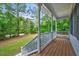 Spacious covered front porch offers serene views of the surrounding wooded landscape at 123 Alan Ln, Clayton, NC 27520