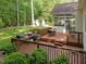 Entertain on the lovely back deck with an outdoor kitchen, table, chairs, and lush greenery all around at 1245 Torchlight Way, Raleigh, NC 27603