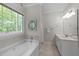 Relaxing bathroom with soaking tub, natural light, and vanity with sink at 1245 Torchlight Way, Raleigh, NC 27603