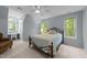 Comfortable bedroom with desk and chair setup, two windows, and a ceiling fan at 1245 Torchlight Way, Raleigh, NC 27603