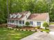 An exterior view of a single story home with lush lawn and garden and a long driveway at 1245 Torchlight Way, Raleigh, NC 27603
