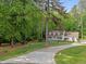 Charming home with a long driveway and lush landscaping on a large wooded lot at 1245 Torchlight Way, Raleigh, NC 27603