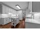 Bright kitchen featuring white cabinetry, an island, and hardwood floors at 1245 Torchlight Way, Raleigh, NC 27603