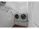 Efficient laundry room featuring side-by-side washer and dryer on pedestals with overhead shelving at 1245 Torchlight Way, Raleigh, NC 27603